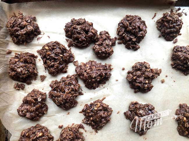 more than a dozen no-bake cookies scattered on a silver baking sheet